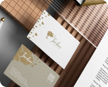 Mockup da papelaria da Clínica Jardim, com cartões em verde e dourado sobre madeira